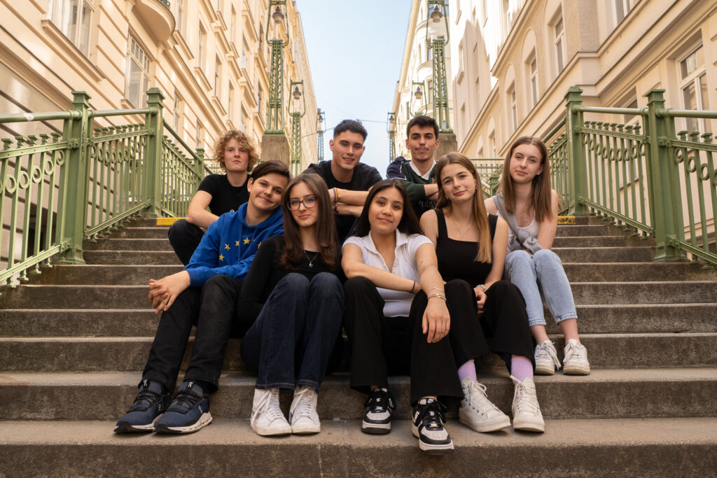 Eine Gruppe Jugendlicher sitzt gemeinsam auf einer Treppe.